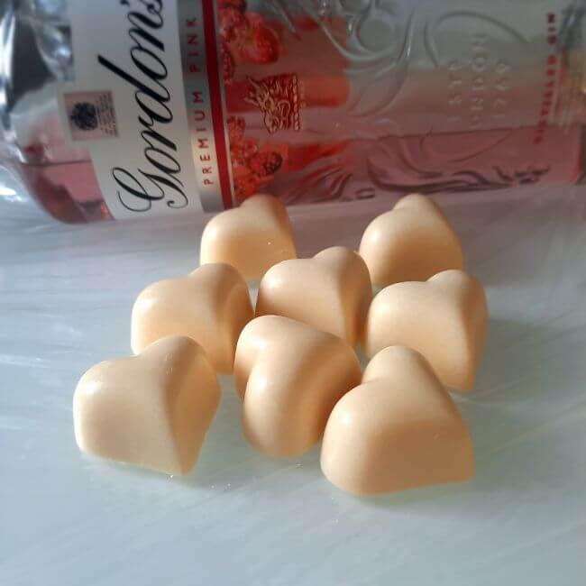 white chocolate heart shaped pink gin truffles, from the Luxury Chocolate Drawer Box , next to bottle of Gordons pink gin on iy's side.